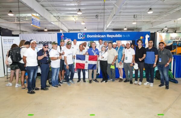 La República Dominicana fortaleció su presencia en la feria EAA AirVenture Oshkosh 2026, considerada el mayor evento de aviación del mundo, al promover el país como destino para la aviación general y presentar el primer avión experimental Van’s RV-8 ensamblado y certificado en territorio dominicano. Durante la feria, celebrada del 20 al 26 de julio en Oshkosh, Wisconsin (Estados Unidos), el Departamento Aeroportuario (DA) y el Ministerio de Turismo orientaron a pilotos y visitantes sobre las facilidades disponibles para la aviación privada no comercial, así como los atractivos turísticos y la infraestructura aeroportuaria del país. Uno de los principales atractivos fue el Van’s RV-8, construido por los aviadores dominicanos Carlos Sanlley, Alejandro Marranzini y Andrés Sánchez, el primer modelo de este tipo ensamblado en la República Dominicana y certificado por las autoridades aeronáuticas nacionales. La aeronave también se convirtió en el segundo avión experimental dominicano en realizar un vuelo internacional hasta Oshkosh. Sanlley explicó que el proyecto tomó cinco años de desarrollo y destacó que la construcción de este tipo de aeronaves va más allá del ensamblaje de piezas, ya que requiere fabricar componentes y seguir estrictos procesos técnicos. Durante la participación dominicana también se rindió homenaje al fallecido piloto Franklin Polanco, a quien el subdirector del Departamento Aeroportuario, Luis Cabrera, definió como una de las figuras más influyentes de la aviación moderna del país. La edición 2026 de AirVenture Oshkosh reunió durante siete días a fabricantes, pilotos, estudiantes y aficionados de la aviación general, militar, experimental e histórica, registrando una de las mayores asistencias en la historia del evento.
