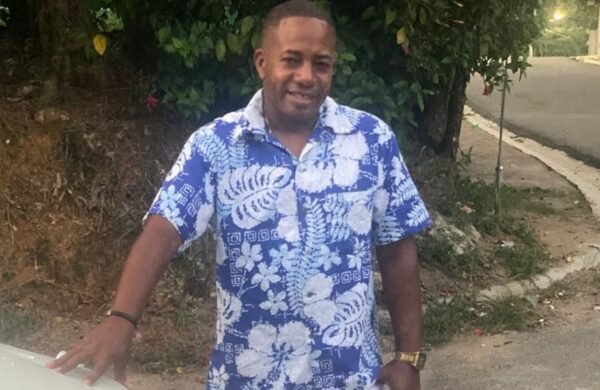 La Fiscalía de San Cristóbal informó este domingo que continúa investigando la muerte de Miguel Antonio Valenzuela, conocido como “Miguelito”, a pesar de que el informe preliminar de la autopsia establece que falleció a causa de una infección por leptospirosis que le provocó una trombocitopenia o disminución severa de plaquetas. En un comunicado, el Ministerio Público explicó que el examen realizado por el Instituto Nacional de Patología Forense (Inacif) determinó de manera preliminar que la causa del fallecimiento fue un proceso infeccioso bacteriano. Sin embargo, precisó que las investigaciones permanecen abiertas debido a las denuncias de familiares, quienes aseguran que Valenzuela habría sido víctima de maltratos mientras permanecía bajo custodia policial. Según el informe oficial, el hombre, de 44 años, fue detenido el 8 de julio por agentes de la Policía Nacional, acusado de vender rifas de manera irregular utilizando un dispositivo electrónico. Permaneció bajo custodia hasta el 13 de julio, cuando un tribunal ordenó su libertad. La Fiscalía indicó que, tras salir del Palacio de Justicia, Valenzuela comenzó a sentirse mal y fue trasladado al Hospital Regional Docente Juan Pablo Pina, donde presentó dificultad respiratoria, sarpullido, petequias y hemorragia conjuntival. Posteriormente fue ingresado en la unidad de cuidados intensivos, donde falleció esa misma noche tras sufrir un paro cardiorrespiratorio. El Inacif informó que la autopsia evidenció daños en distintos órganos compatibles con un proceso inflamatorio y que las pruebas de laboratorio confirmaron la presencia de la bacteria causante de la leptospirosis, sustentando de forma preliminar la causa de muerte. No obstante, el Ministerio Público reiteró que continuará desarrollando las diligencias investigativas para esclarecer las circunstancias del caso y determinar si existen responsabilidades vinculadas a las denuncias realizadas por los familiares. La muerte de “Miguelito” ha generado protestas en San Cristóbal, donde allegados, vecinos y organizaciones sociales exigen una investigación exhaustiva, al denunciar que el hombre presentó problemas de salud durante su detención y no habría recibido atención médica oportuna. Hasta el momento, las autoridades no han informado si el informe definitivo de la autopsia abordará las acusaciones de presunto maltrato bajo custodia policial.