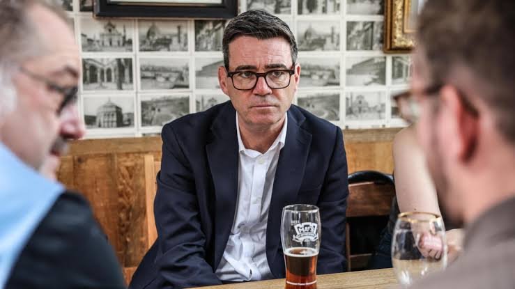 El nuevo primer ministro del Reino Unido, Andy Burnham, anunció una reducción del 20 % del impuesto empresarial para pubs, discotecas y salas de conciertos en Inglaterra, como parte de su estrategia para fortalecer el poder adquisitivo y respaldar al sector del entretenimiento. La medida, que entrará en vigor en abril de 2027, se aplicará únicamente en Inglaterra debido a que la política fiscal sobre empresas se administra de forma independiente en cada territorio del Reino Unido. No obstante, la rebaja no beneficiará a las salas de conciertos de mayor capacidad. Burnham aseguró que busca evitar el cierre de establecimientos emblemáticos del país y afirmó que no permanecerá "de brazos cruzados" mientras estos desaparecen. El Gobierno indicó que la iniciativa será financiada mediante una revisión del régimen fiscal aplicado a negocios que, según las autoridades, no generan una contribución positiva, como los relacionados con cigarrillos electrónicos. Aunque el anuncio fue bien recibido por representantes del sector, algunos empresarios consideran que la medida resulta insuficiente frente a la crisis que enfrentan estos negocios. De acuerdo con la British Beer and Pub Association, en el Reino Unido está cerrando aproximadamente un pub por día. En otro ámbito, más de 120 millonarios británicos, entre ellos el exfutbolista Gary Lineker, solicitaron al nuevo Gobierno un aumento de los impuestos para las rentas más altas, al considerar que esa medida podría generar alrededor de 24,000 millones de libras para las finanzas públicas. Asimismo, Burnham anunció la suspensión de una reforma impulsada por el anterior Gobierno que contemplaba la liberación anticipada de unos 6,000 reclusos, al señalar que la seguridad de la población será una prioridad de su administración.