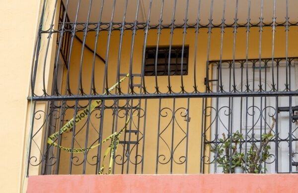 La Policía Nacional informó que los primeros resultados de la investigación sobre la muerte de Lucinda Emelinda Rodríguez Restituyo, de 68 años, y su hijo Óscar Gabriel Curiel Rodríguez, de 41, hallados sin vida en un apartamento del sector Bella Vista, en el Distrito Nacional, indican que ambos cuerpos no presentan signos de violencia. El vocero de la institución, Diego Pesqueira, explicó que se trata de un informe preliminar y que será el Instituto Nacional de Ciencias Forenses (Inacif) el organismo encargado de establecer oficialmente la causa de los fallecimientos, una vez concluyan las autopsias. Las investigaciones también revelan que los familiares de las víctimas creían que madre e hijo habían salido de la ciudad durante el fin de semana, luego de que Lucinda comunicara a otro de sus hijos, miembro de las Fuerzas Armadas, que realizarían un viaje. Mientras sus parientes pensaban que ambos estaban fuera, residentes del edificio comenzaron a percibir un fuerte hedor, que inicialmente atribuyeron a un animal muerto. Días después, las autoridades localizaron los cuerpos en avanzado estado de descomposición dentro del apartamento. Vecinos describieron a las víctimas como personas reservadas y tranquilas, con escaso contacto con los demás residentes, y señalaron que solían salir únicamente para pasear a su perro. La Policía informó que las investigaciones continúan y que han sido entrevistados familiares, vecinos y comerciantes de la zona, en espera de los resultados oficiales del Inacif que permitan esclarecer las circunstancias de ambas muertes.